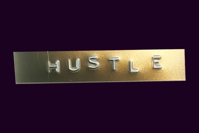 An image of the word Hustle on a gold and black background