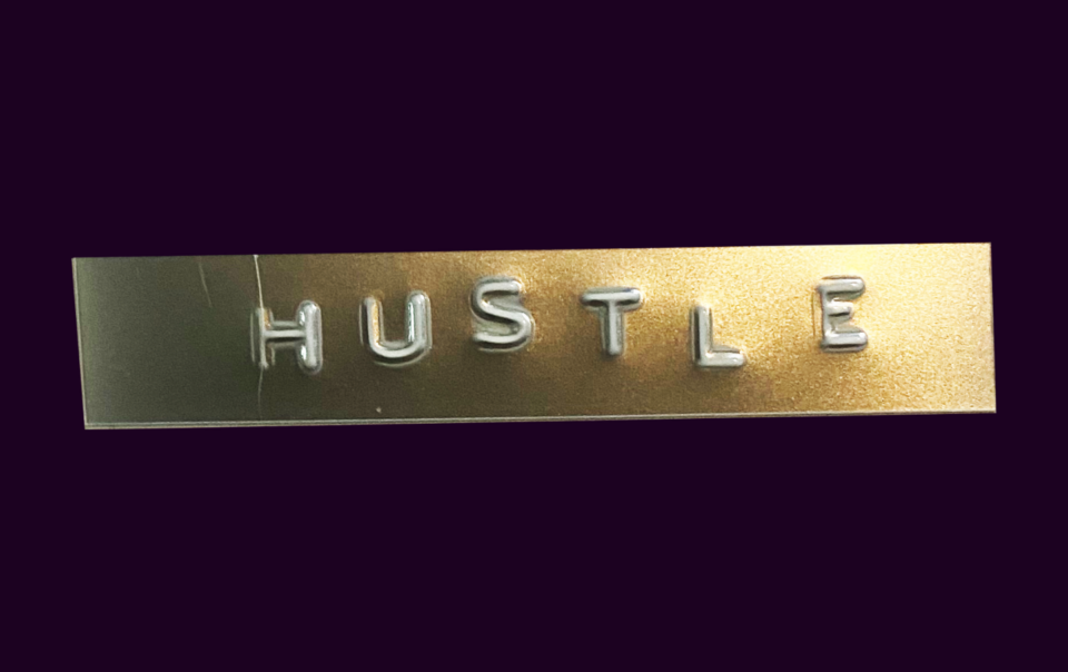 An image of the word Hustle on a gold and black background