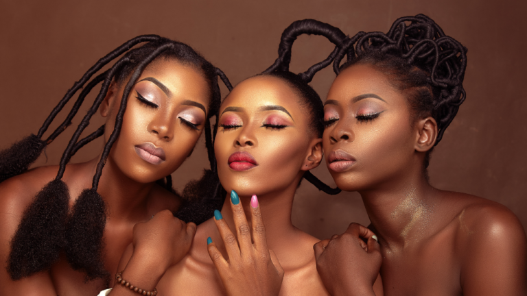 Three luminous black women leaning towards each other with their eyes closed